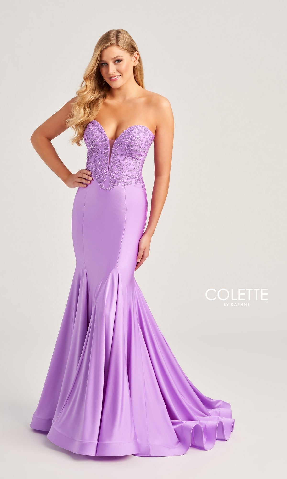 A woman poses elegantly against a plain light background, wearing the Colette Strapless Long Mermaid Prom Dress CL5112 in lavender with a lace bodice and flared skirt.